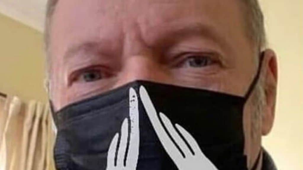 Vasco Rossi in primo piano con una mascherina nera addossocon la mascherina