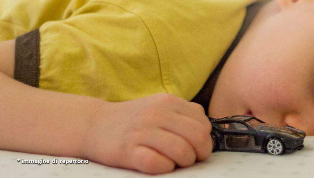 bambino che dorme con in mano una macchinina