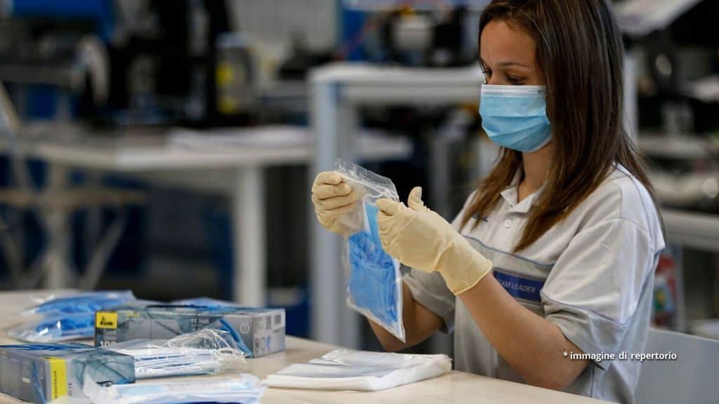 Un'operaia confeziona mascherine per il Coronavirus