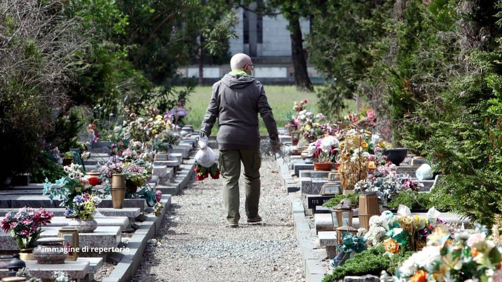 un uomo che cammina dentro un cimitero