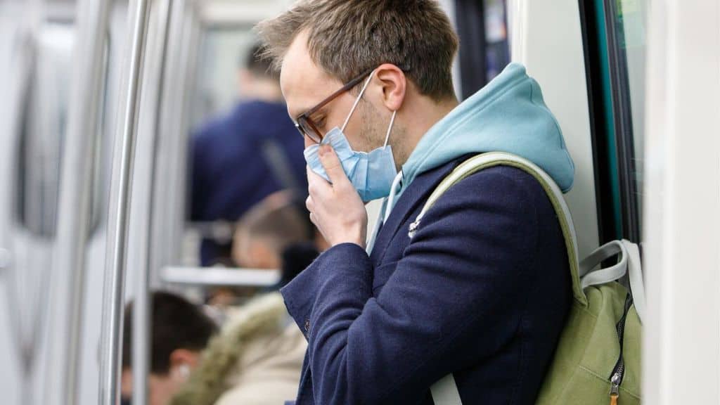 Un uomo con mascherina in metropolitana