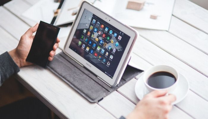 Uomo guarda il tablet con un caffè