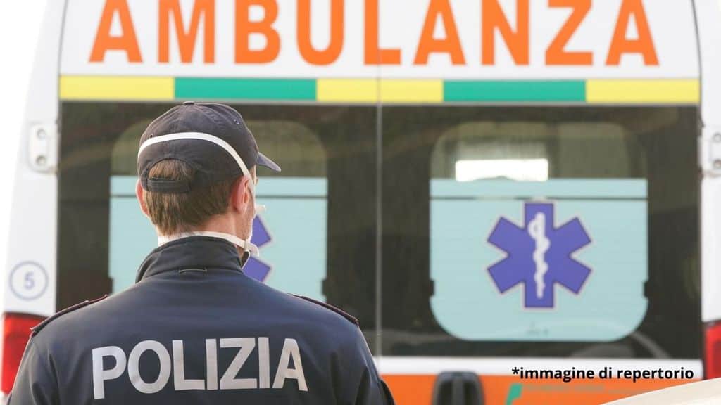 Un poliziotto di fronte a un ambulanza