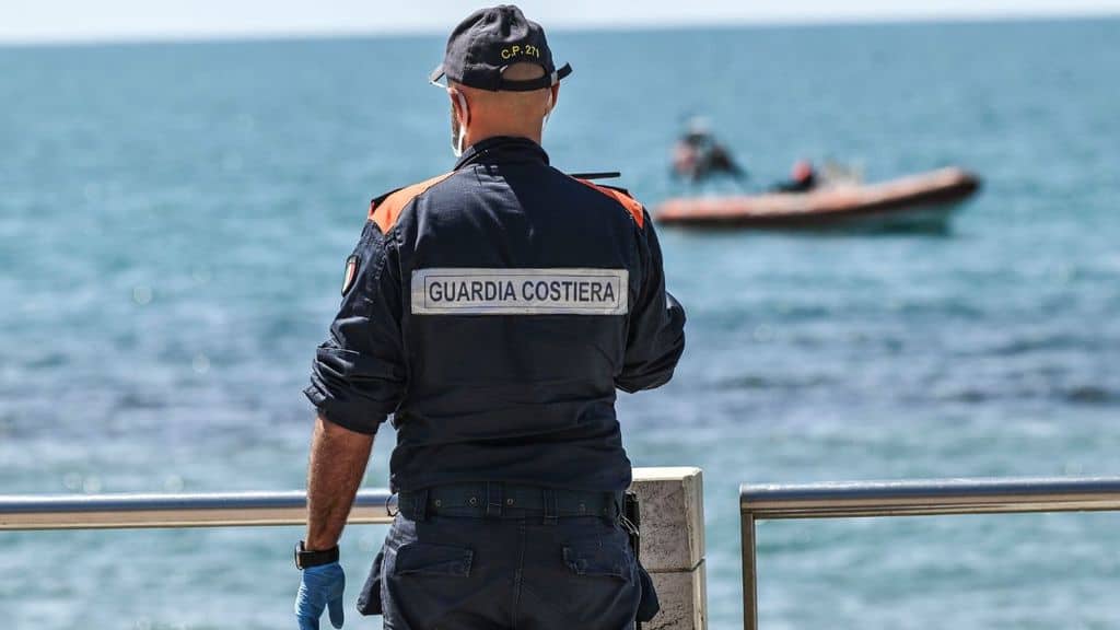 membro della guardia costiera guarda il mare dalla spiaggia