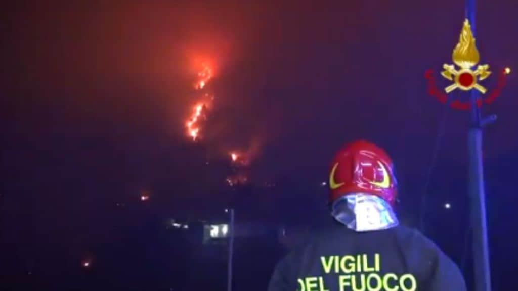 Vigile del fuoco di spalle guarda l'incendio ad Altofonte