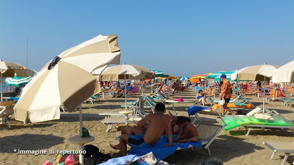 persone sotto gli ombrelloni in spiaggia