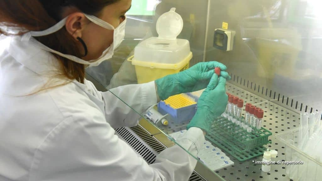 Una scienziata analizza provette in laboratorio
