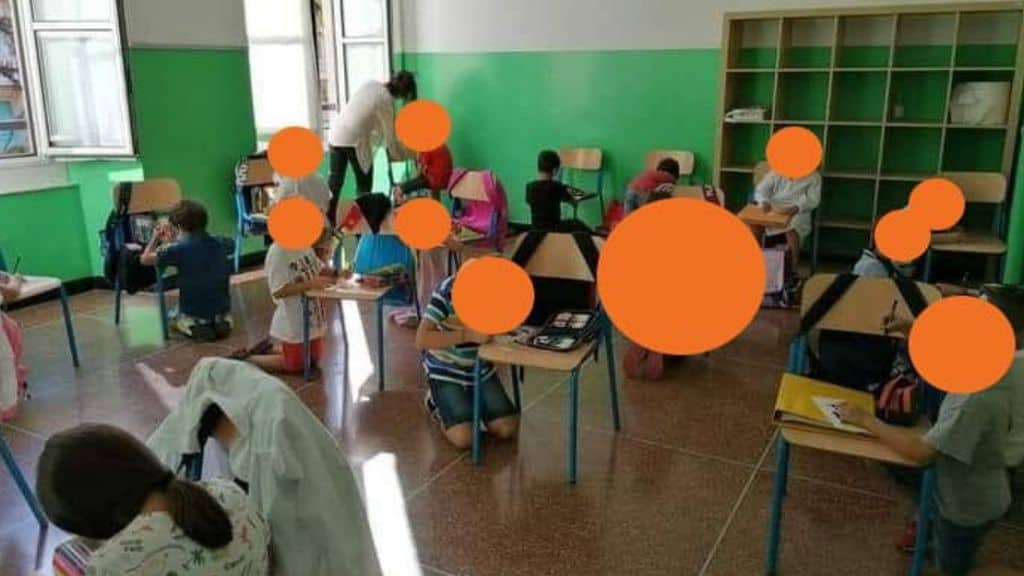 genova bambini seduti per terra a scuola
