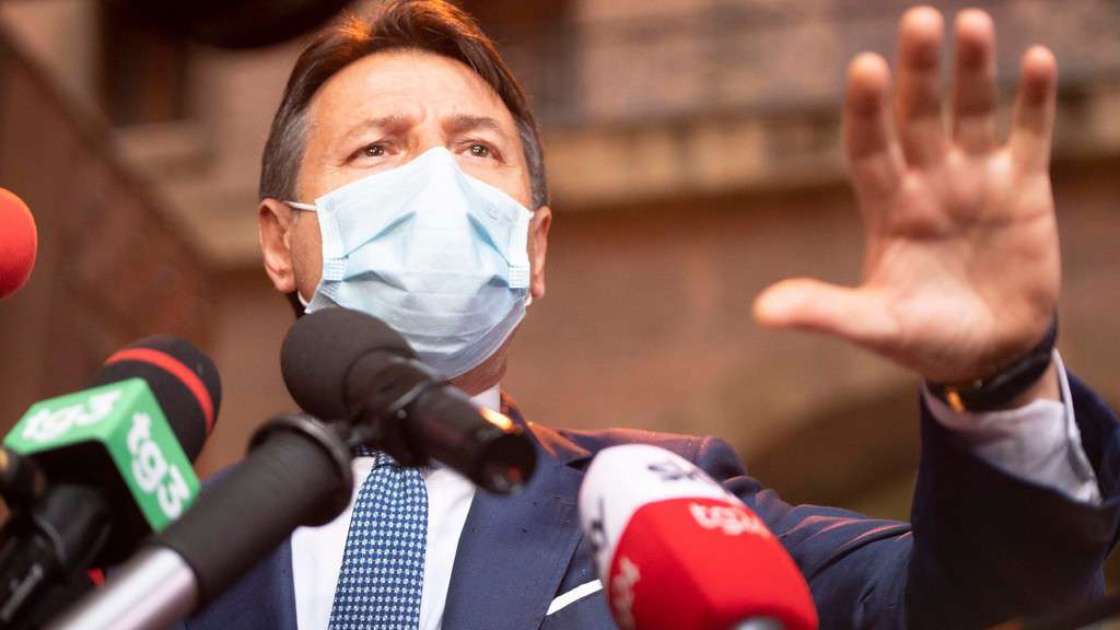 Giuseppe Conte con la mascherina davanti ai microfoni