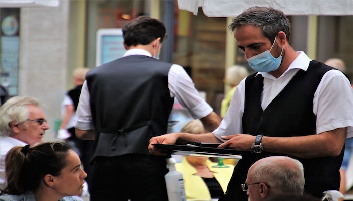 Un cameriere al lavoro in epoca Covid-19