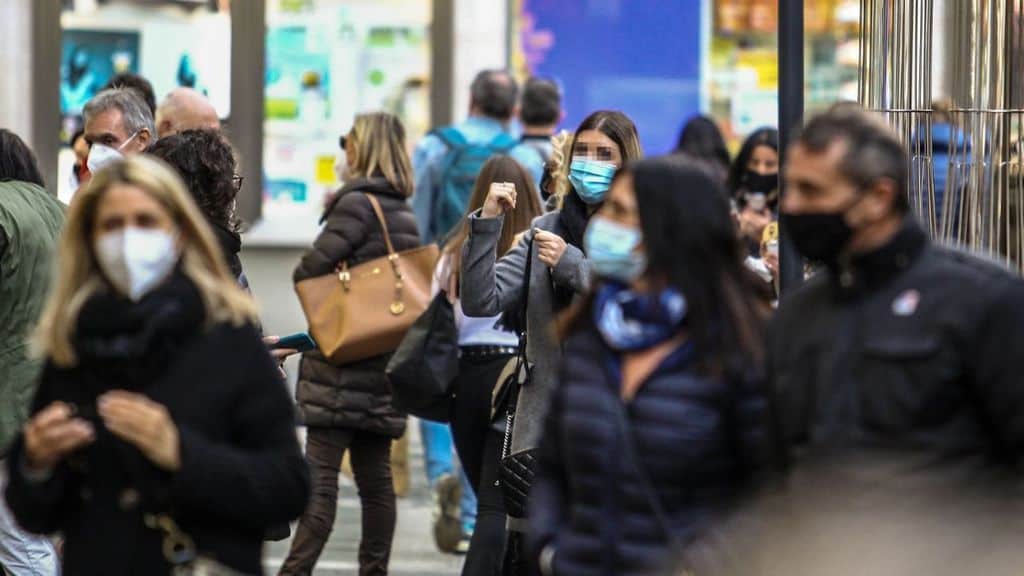 Persone in giro per la città con mascherine