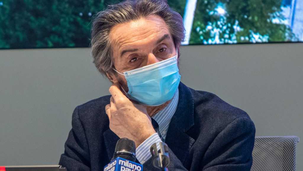 Attilio Fontana con la mascherina di fronte al microfono