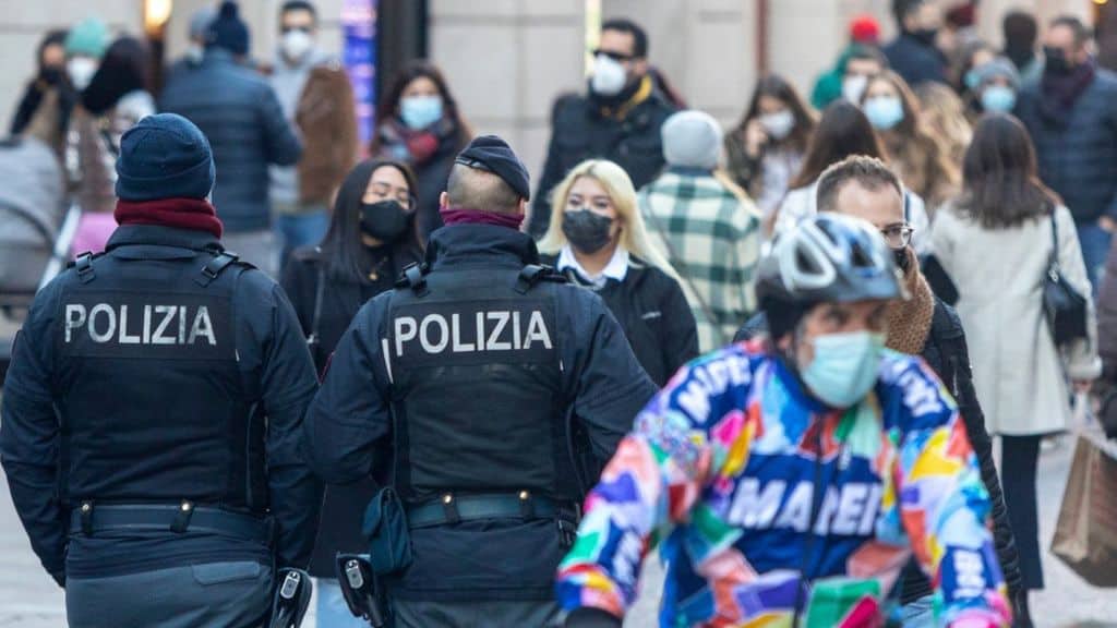 persone a passeggio in città con la mascherina e la polizia