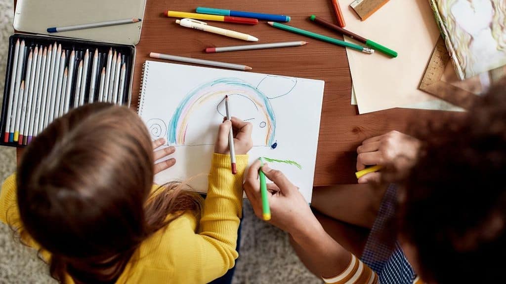 baby sitter e bambino colorano insieme