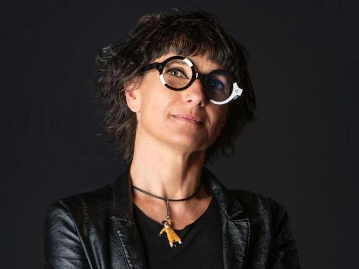 Anna Toscano mentre presenta una delle sue opere, con un sorriso.