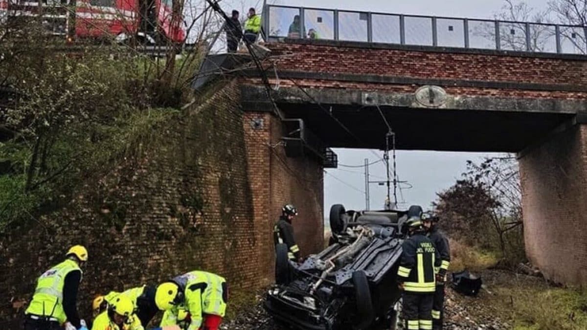 Auto vola giù dal cavalcavia mentre arriva il treno: orrore in Italia. Immagini tremende