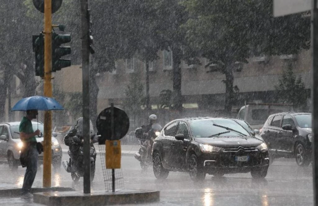 Strada bagnata dalla pioggia con gocce che cadono sull'asfalto